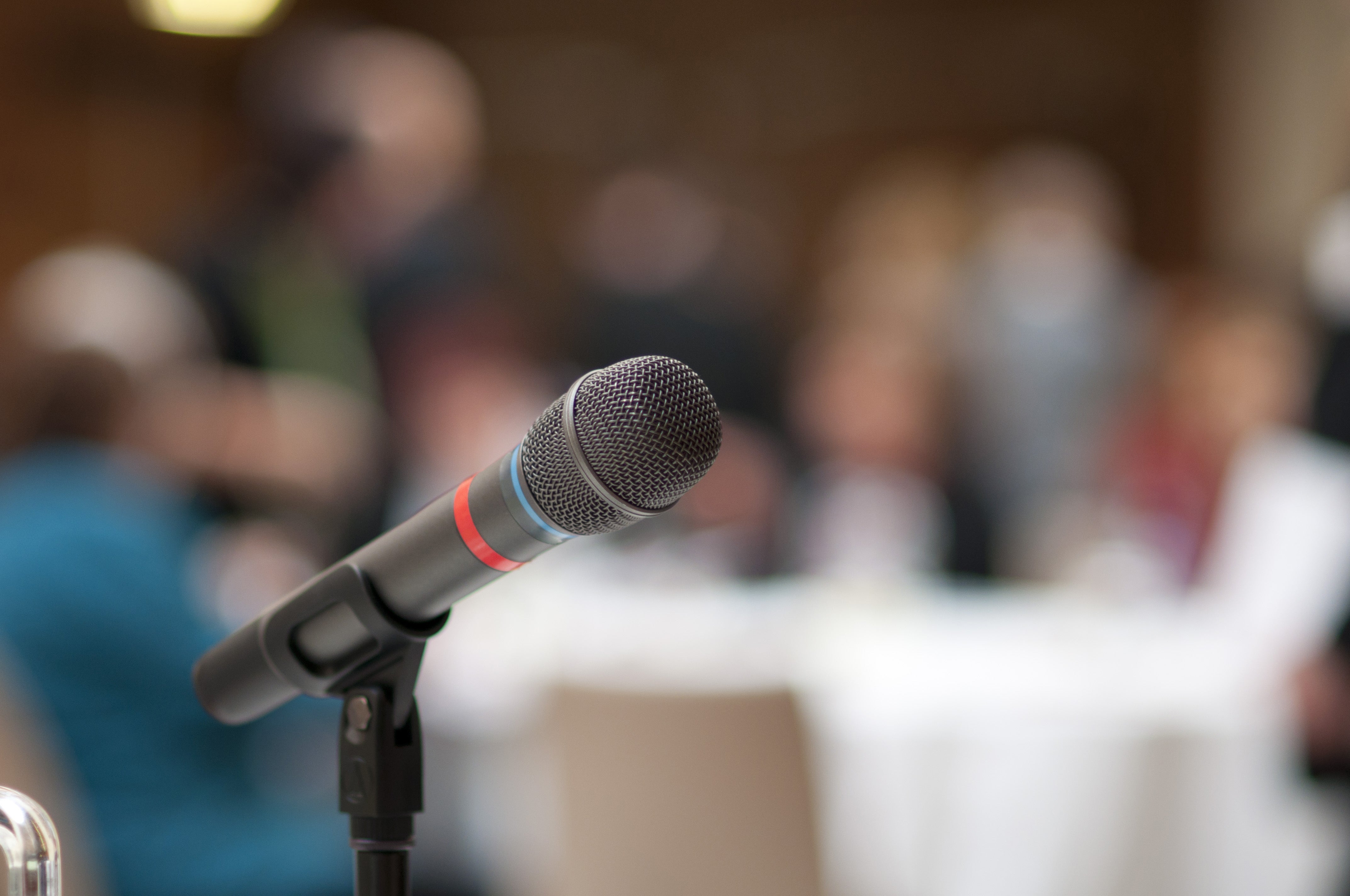 Microphone witht blurry background of people at a meeting